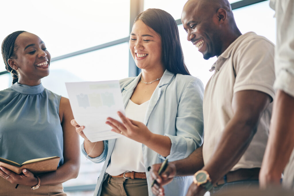 A group of young professionals cheerfully talking in a bright office environment