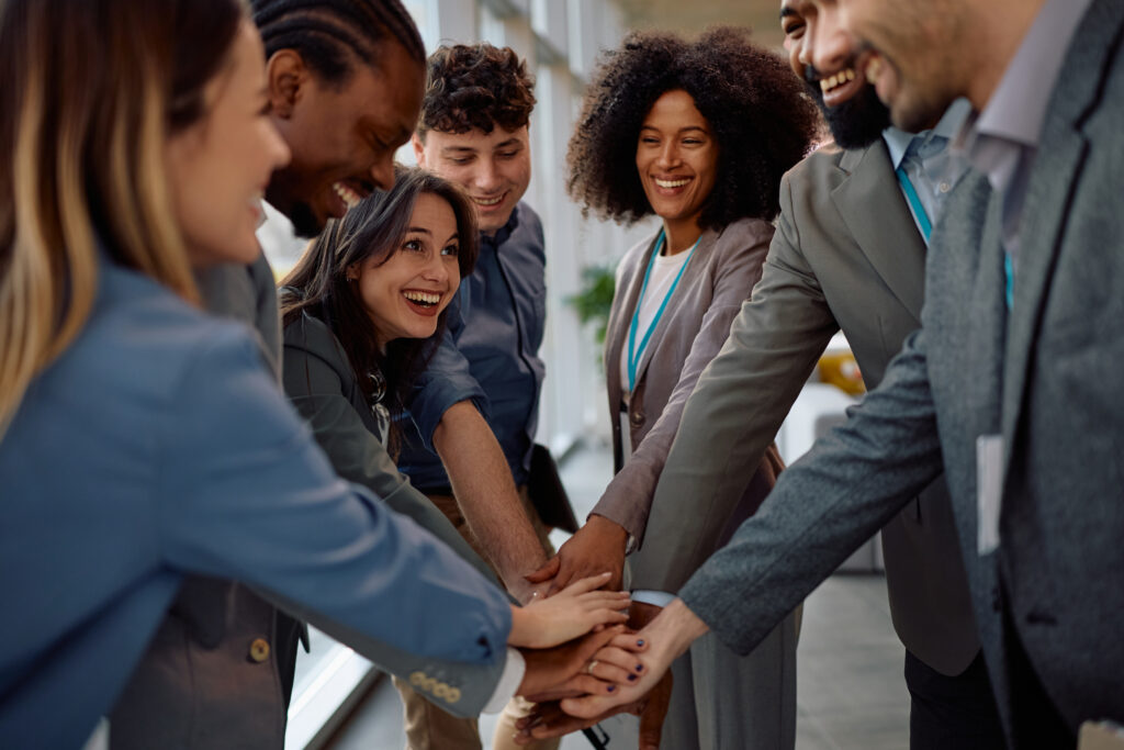 A multiracial team of young professionals joining hands cheerfully